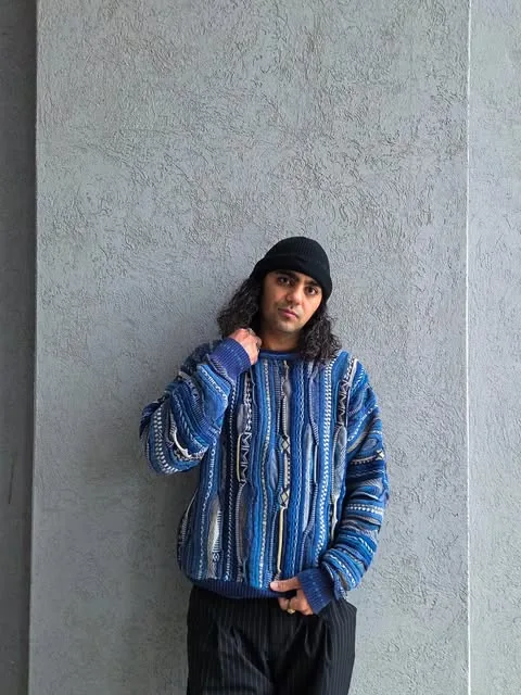 Modelo con buzo tejido azul y gorro negro