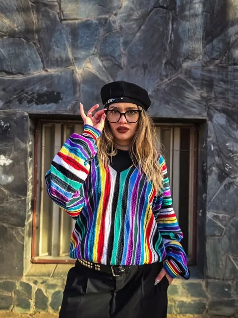 Modelo con buzo tejido arcoíris y boina